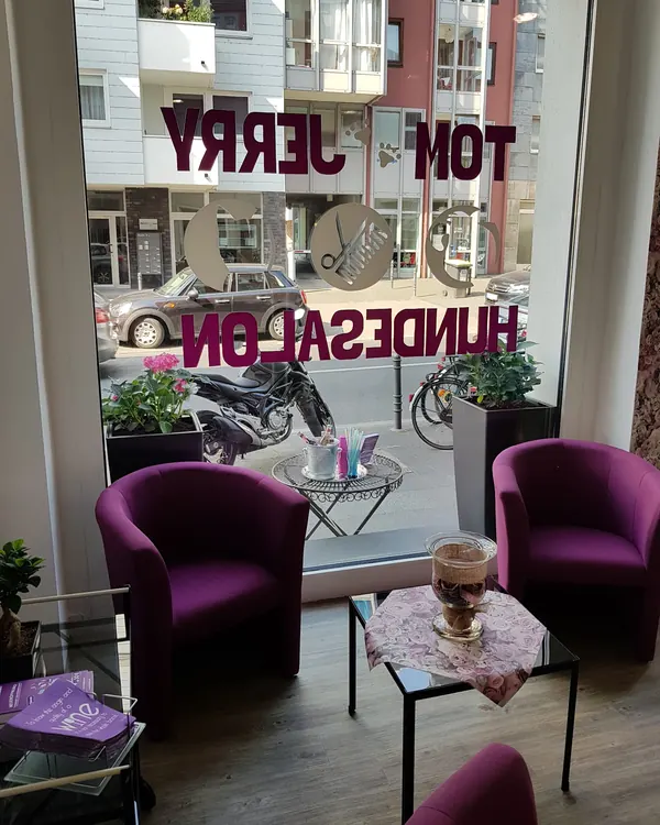 Wartebereich mit lila Sesseln und Schaufensterbeschriftung des Hundesalons